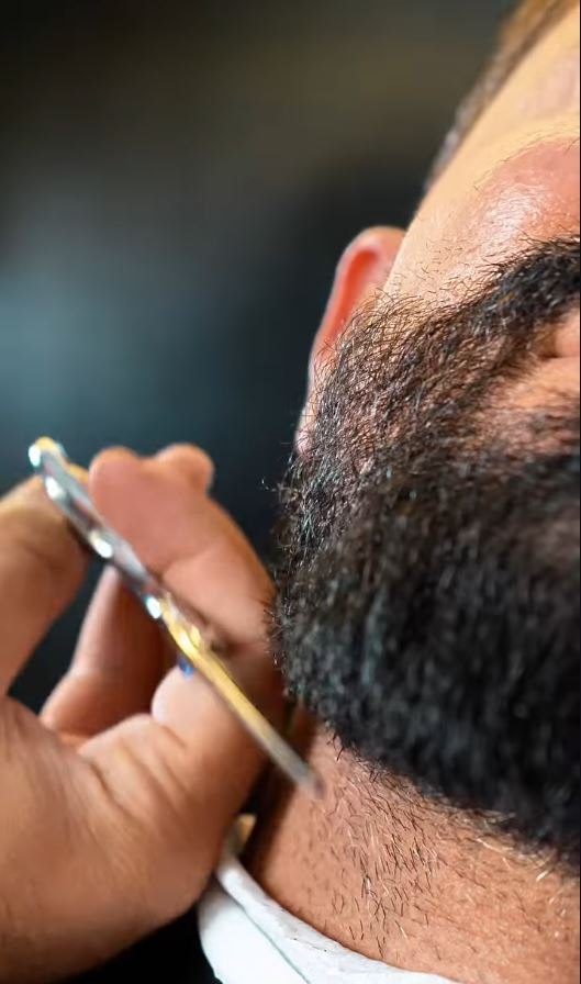 Close-up of beard line being shaped with a razor
