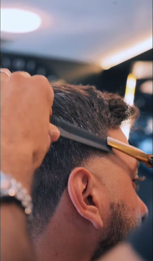 Scissor work over comb on the side of the head